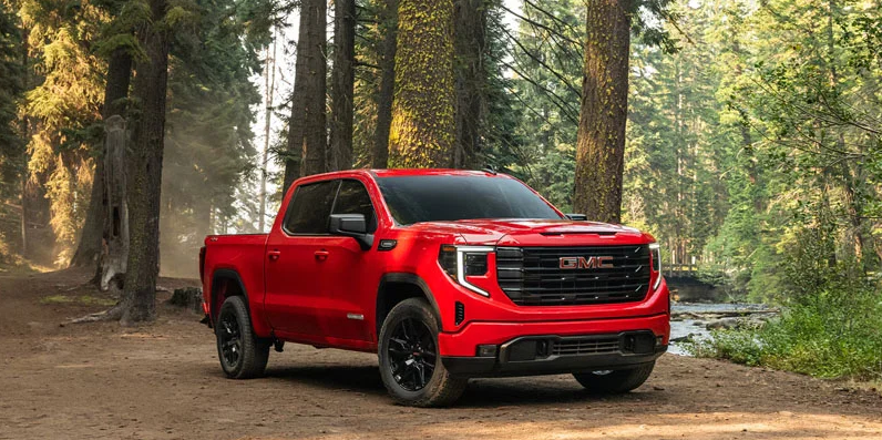 A red 2026 GMC Sierra 1500 parked in the woods.