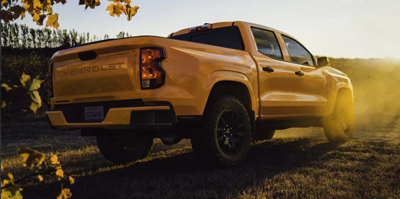 A yellow 2026 Chevrolet Colorado parked in a grass field.