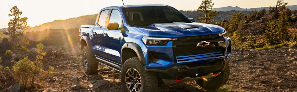 A blue Chevrolet Colorado ZR2 pickup truck off-roading at sunset.